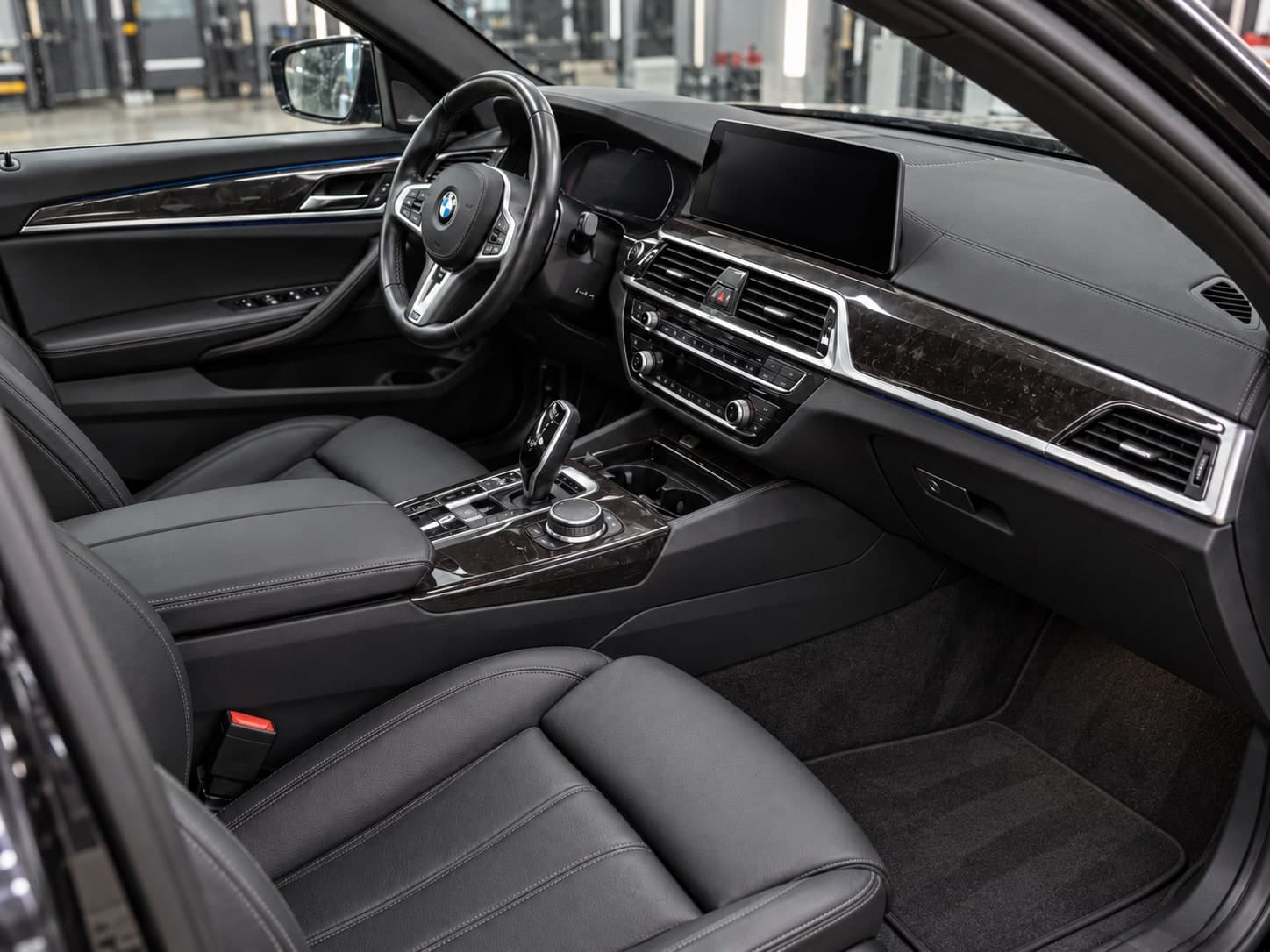 Očišćen BMW enterijer sa kožnim sedištima i centralnom konzolom u detailing studiju